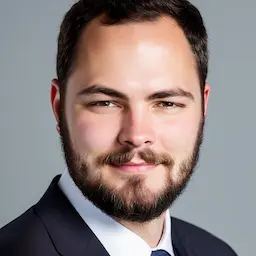 A centered and proffesional portrait of the author Richard Decker wearing a dark colored suit while looking directly at the camera.